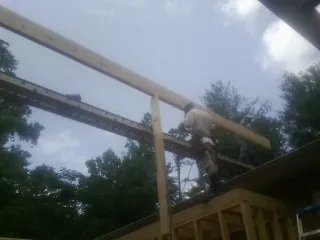 Carpenter setting a ridge beam over a new addition frame — Ice Dam Removal by Roofing Brothers in Moorpark