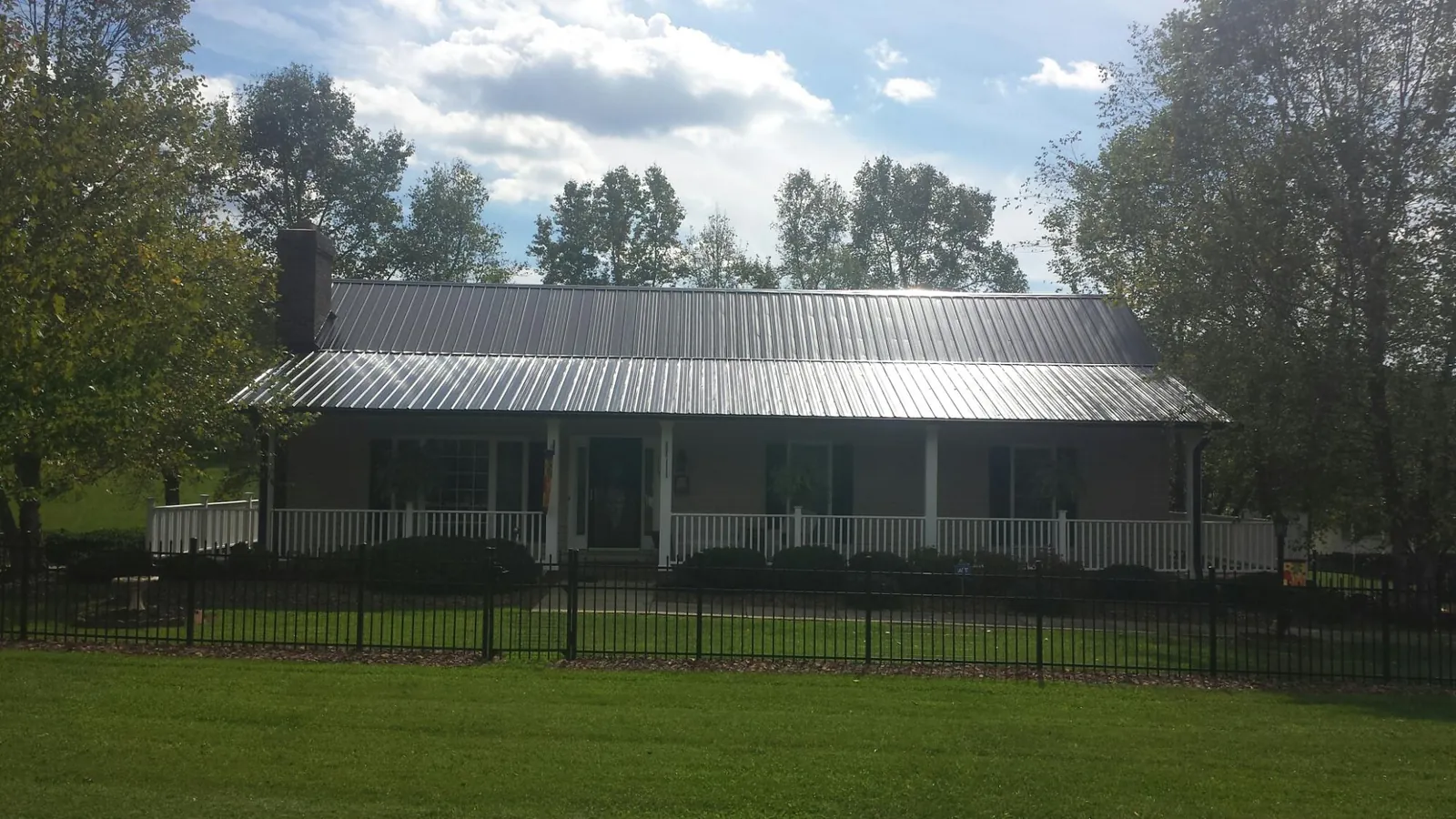 Gray metal roof on a brick ranch with a full width front porch — Gutter Guard Installation work by our crew in Moorpark